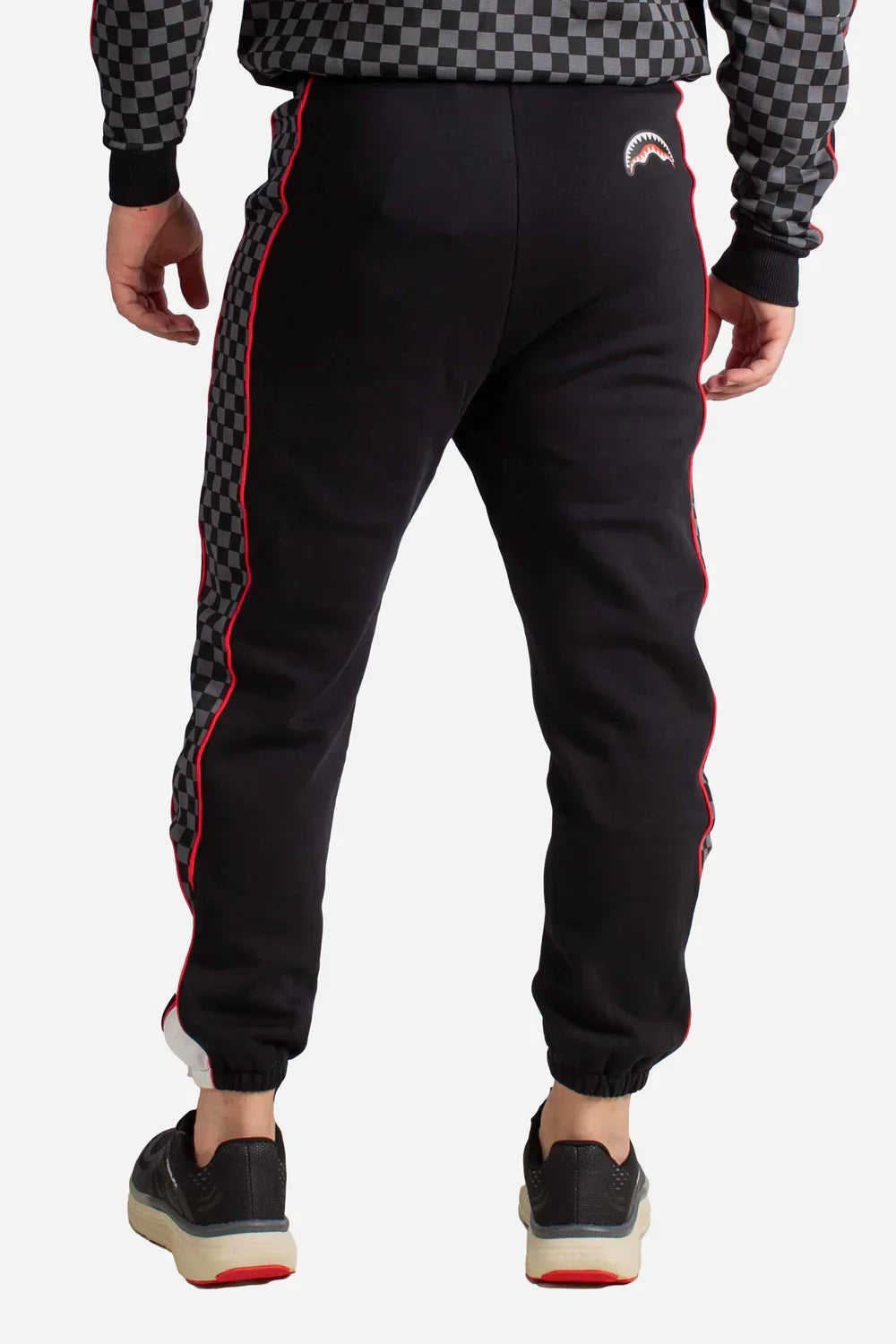Pantaloni uomo neri con bande laterali a scacchi grigi e profilo rosso, stile sportivo