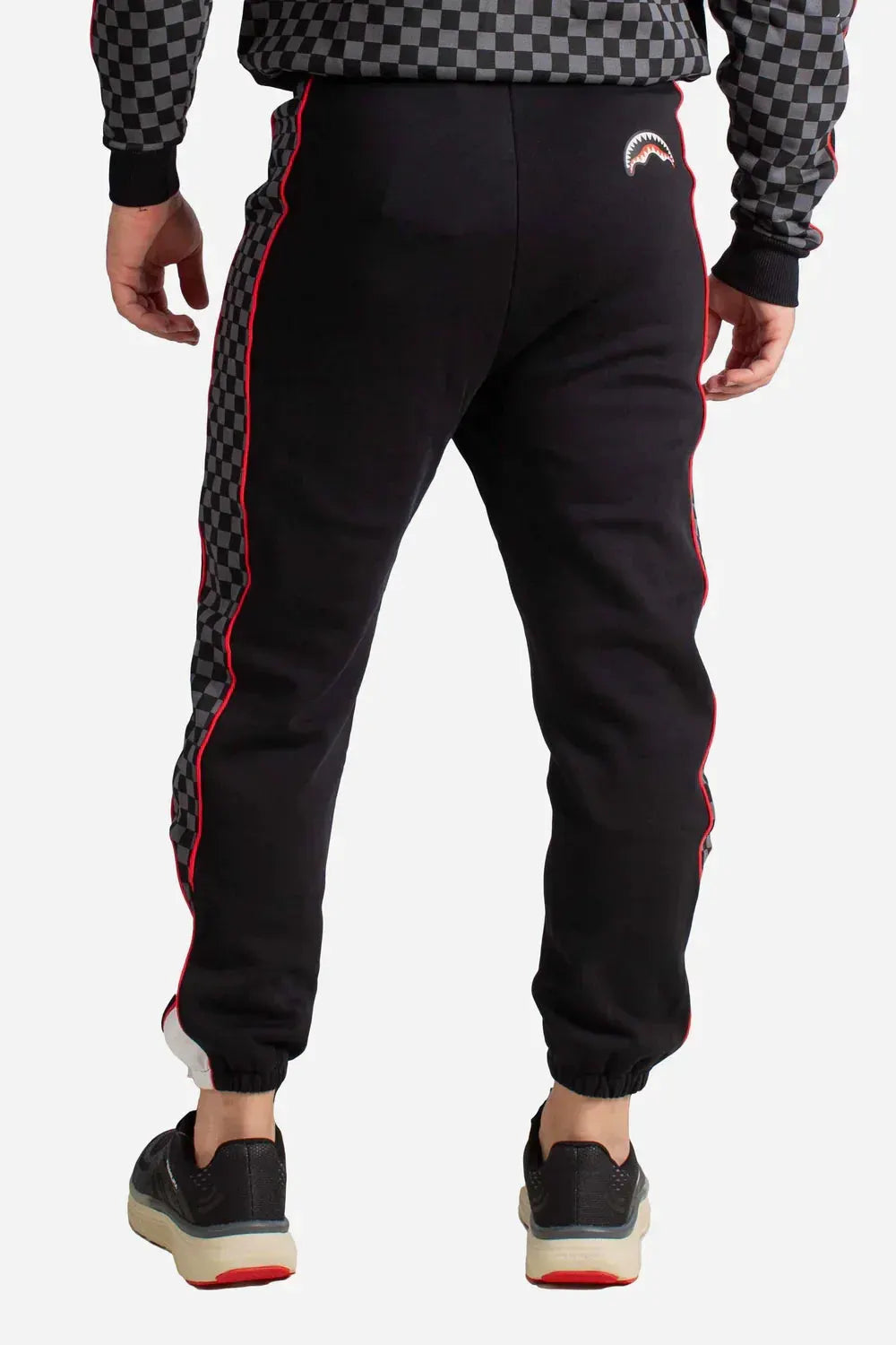 Pantaloni uomo neri con bande laterali a scacchi grigi e profilo rosso, stile sportivo
