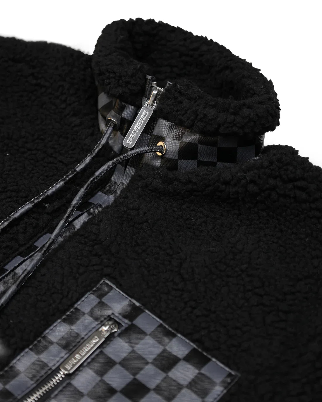 Giacca teddy nera in pile con dettagli a quadretti e zip, moda uomo inverno.