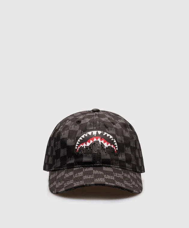 Cappellino baseball nero a quadri con motivo bocca di squalo stilizzata sul davanti.