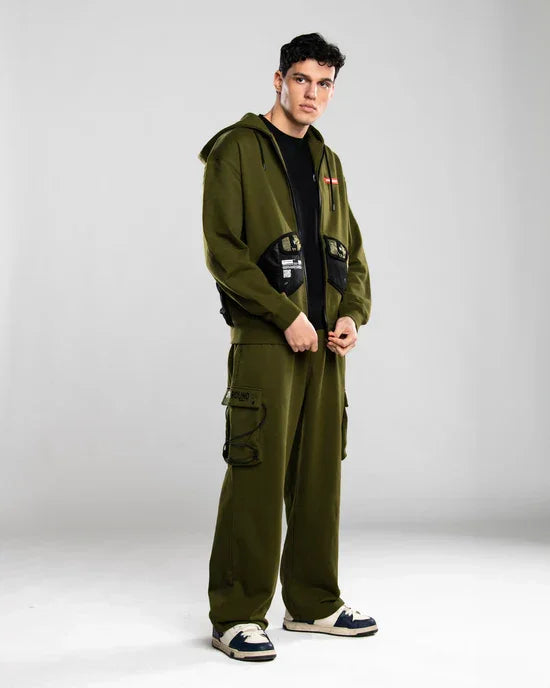 Uomo indossa completo streetwear verde militare con felpa con cappuccio e pantaloni cargo.
