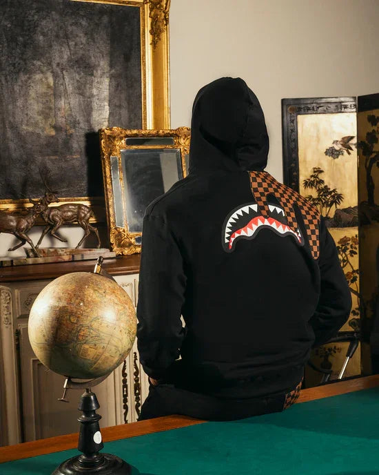 Felpa nera con cappuccio, dettaglio grafico bocca e scacchi arancioni sulla schiena, stile streetwear.