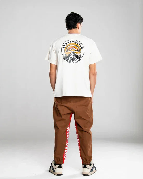 Pantaloni marroni uomo con tasche e dettagli rossi, modello streetwear moderno.