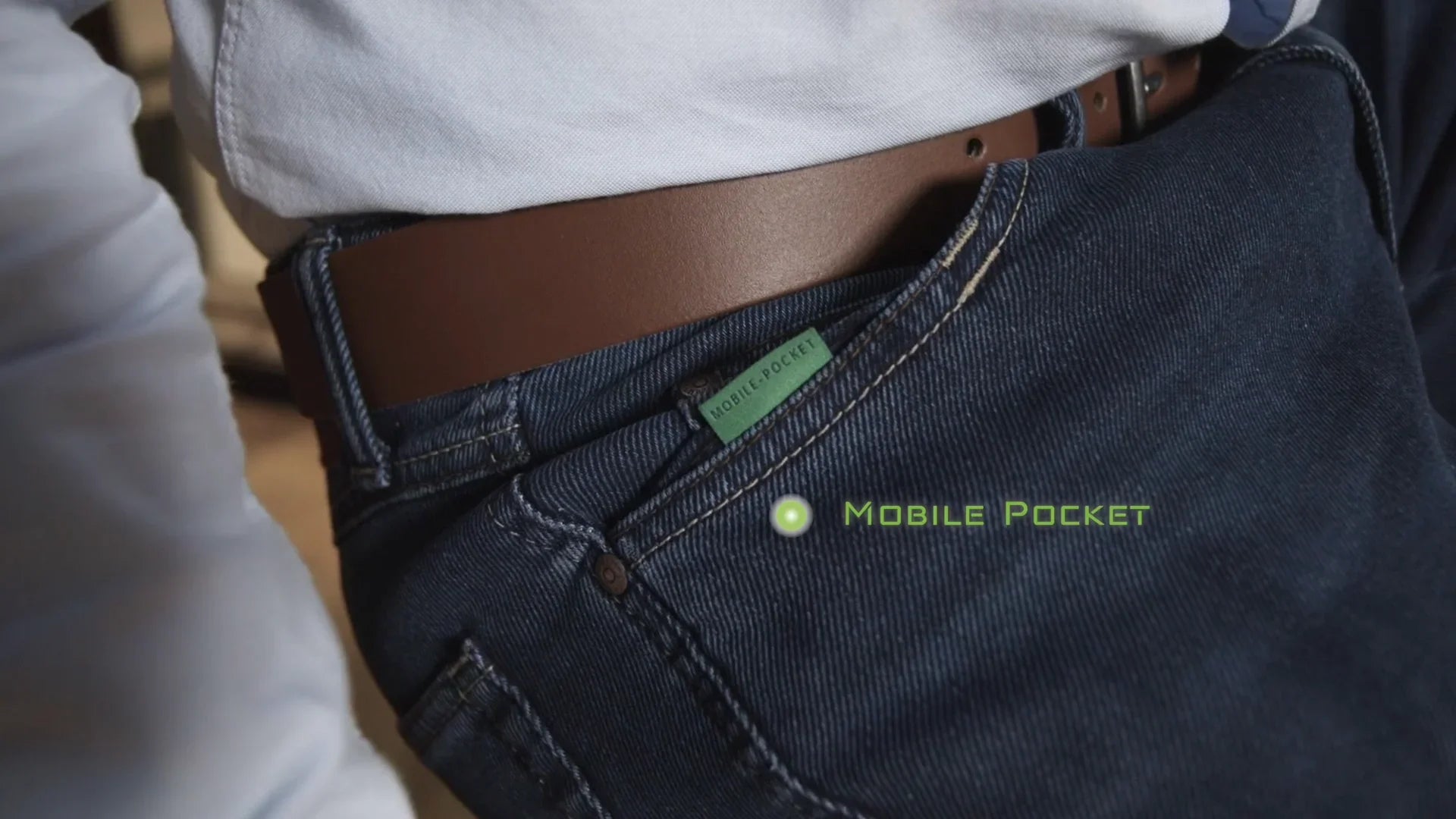 Dettaglio jeans uomo con cintura marrone, focus su tasca mobile pocket, abbigliamento trendy.