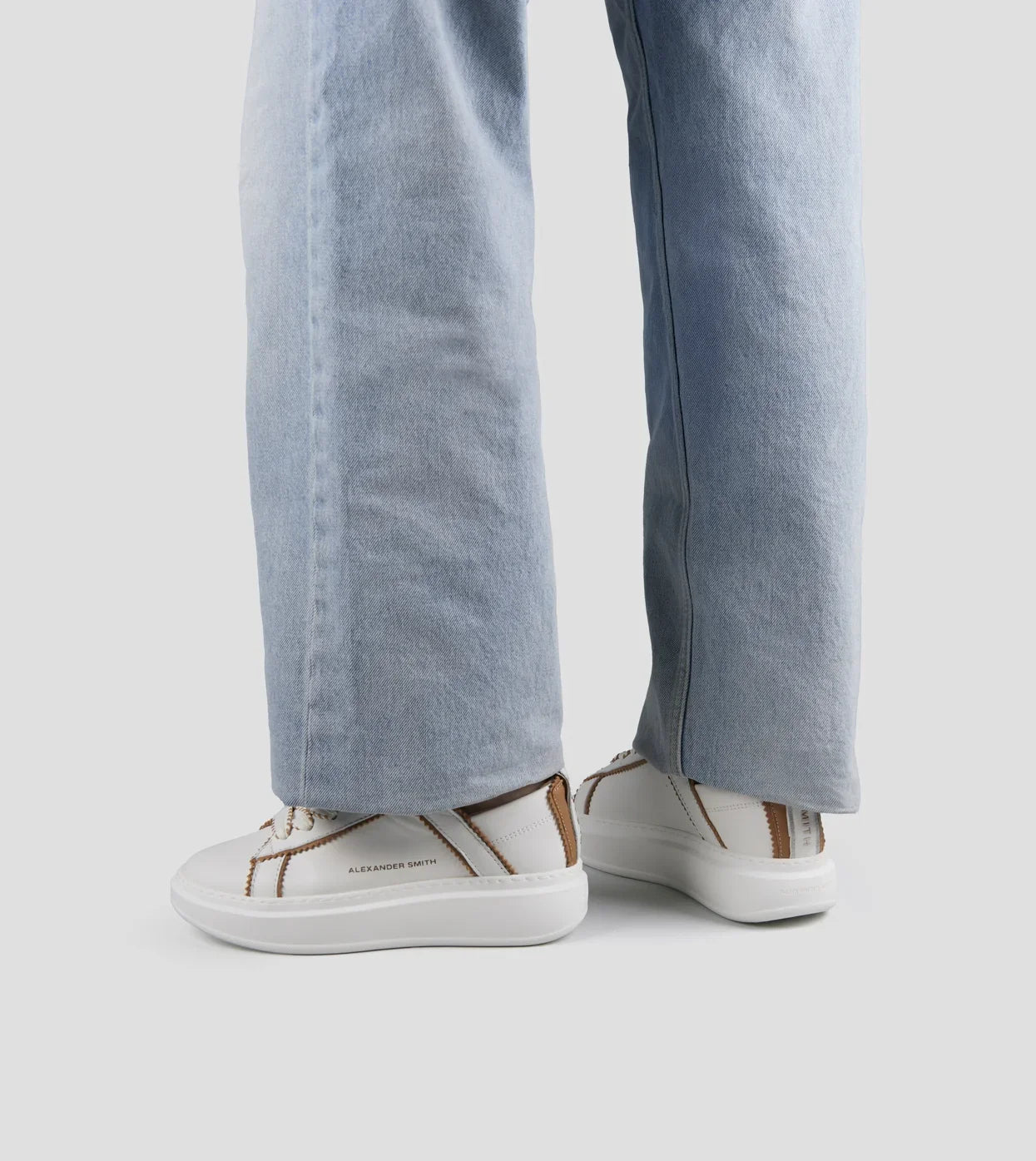 Sneakers donna in pelle bianca con dettagli marroni, indossate con jeans chiari