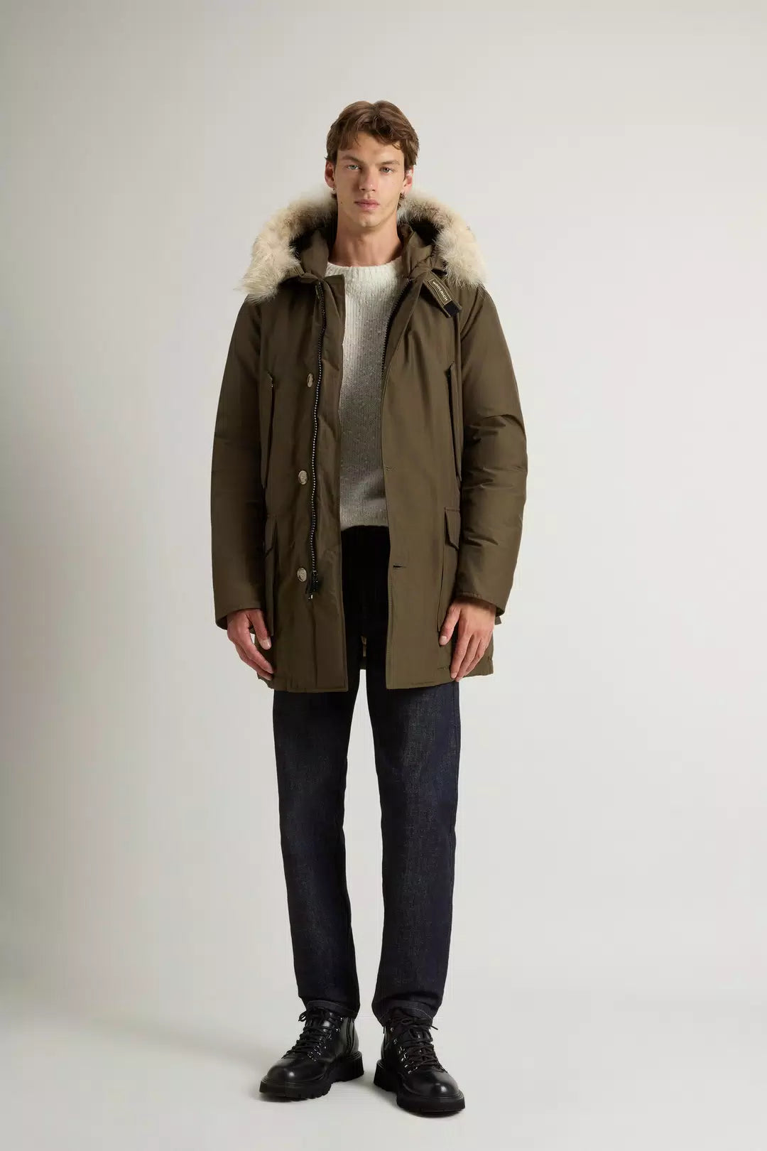 Modello indossa parka verde uomo con cappuccio e pelliccia removibile, look inverno elegante