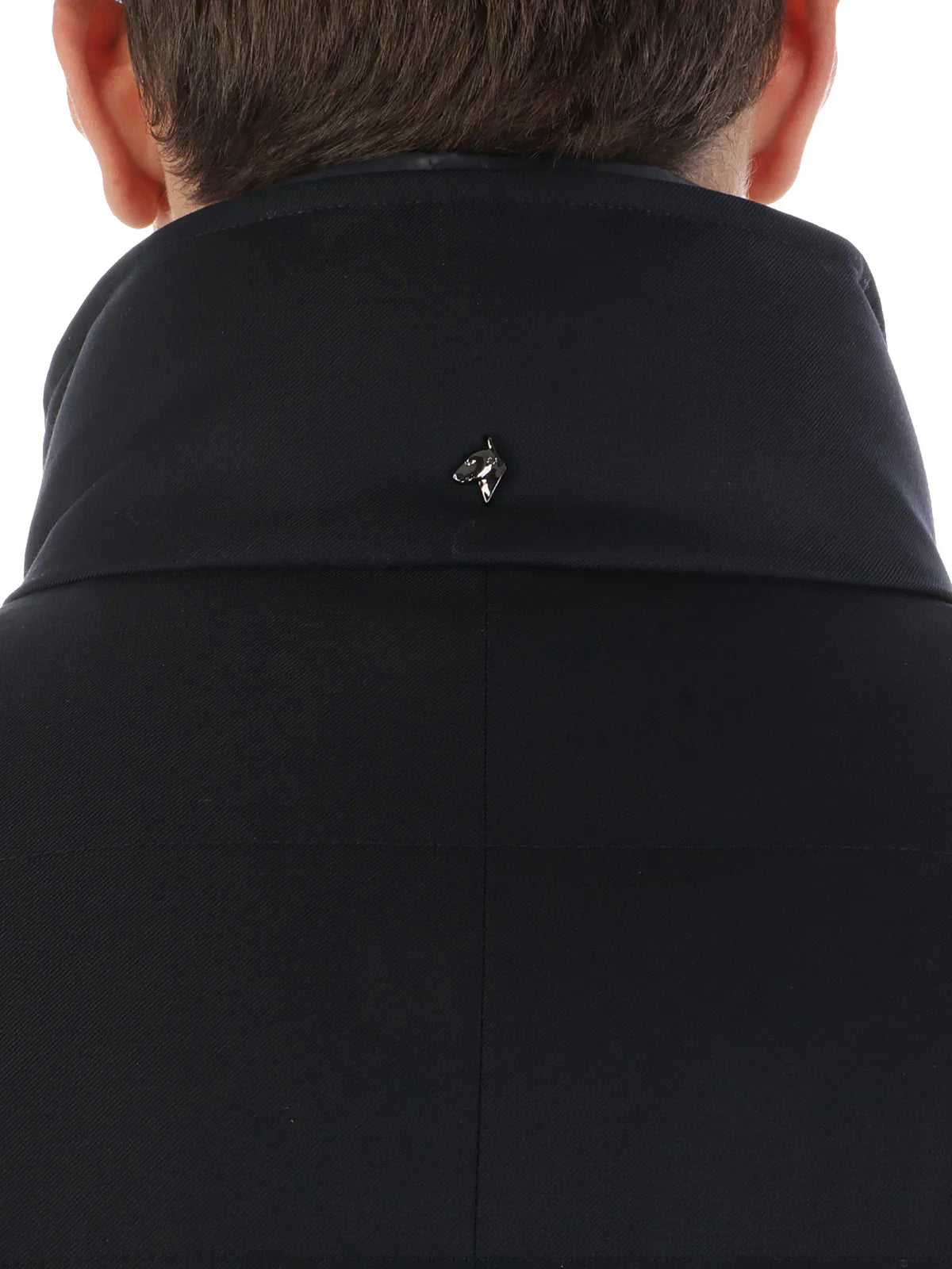 Colletto alto giacca uomo blu con spilla logo cane, dettaglio moda elegante