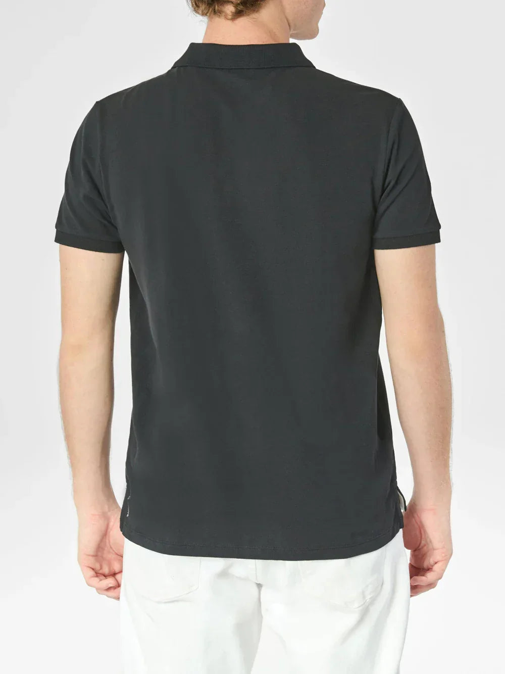 Uomo di spalle con polo nera a maniche corte e pantaloni bianchi, moda casual.