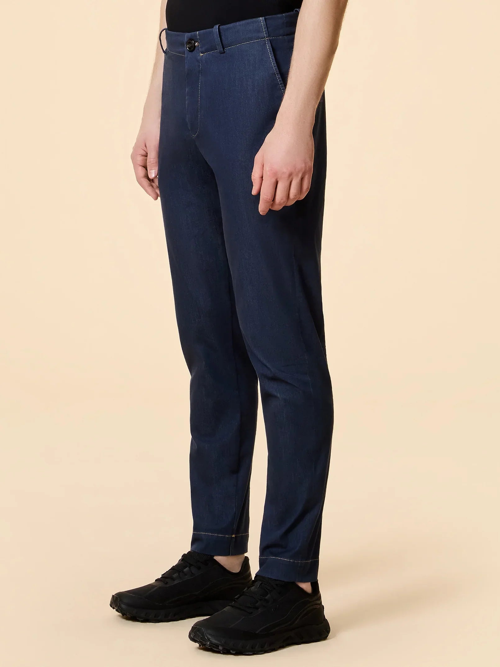 Pantalone uomo blu in denim, vestibilità slim, indossato da modello, scarpe nere sportive