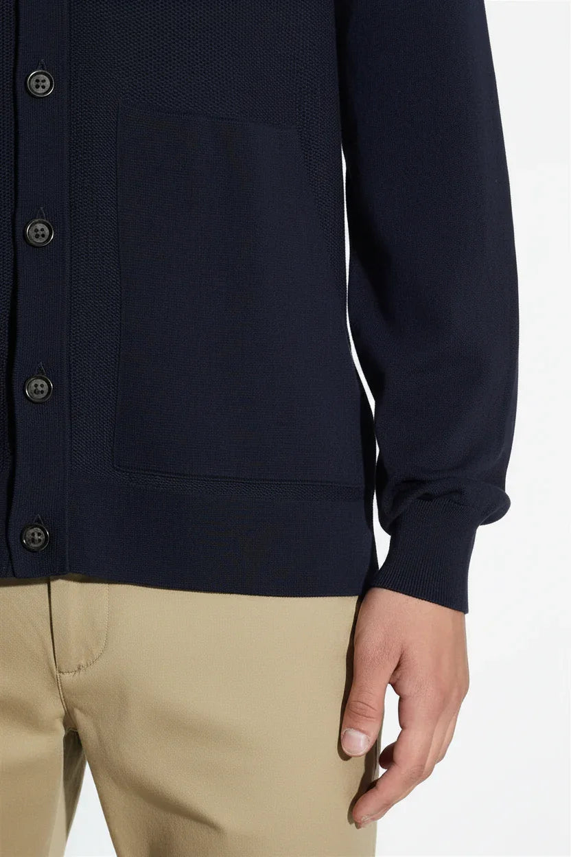 Cardigan blu navy da uomo con bottoni e tasca frontale, abbinato a pantaloni beige