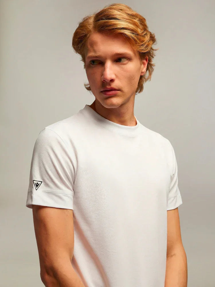Modello indossa t-shirt bianca uomo a maniche corte con logo sulla manica, stile casual