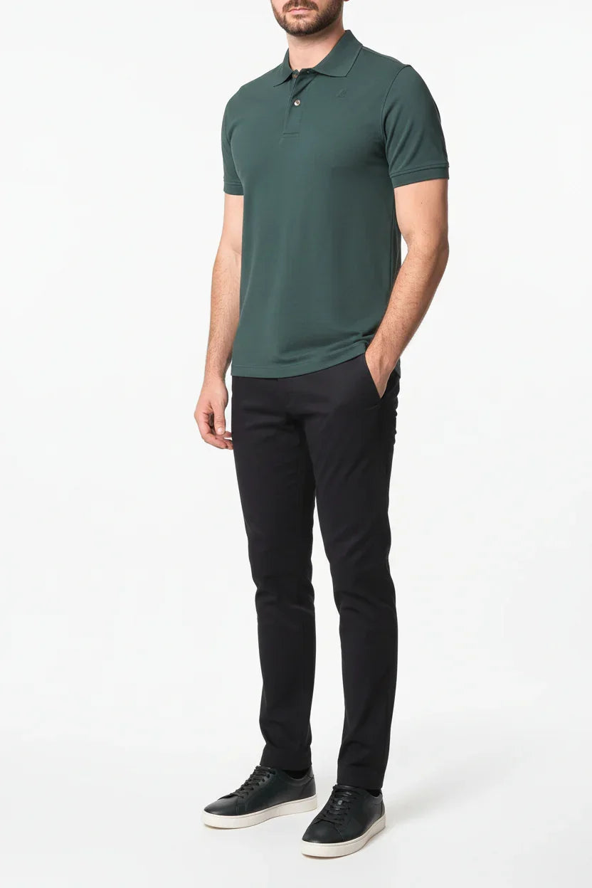 Modello indossa polo verde uomo a maniche corte e pantaloni neri eleganti con sneakers nere