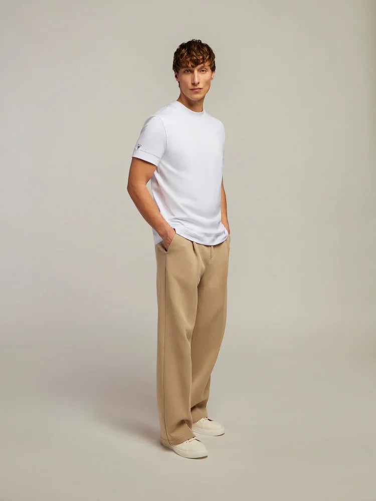 Modello uomo indossa t-shirt bianca e pantaloni beige, look casual elegante.