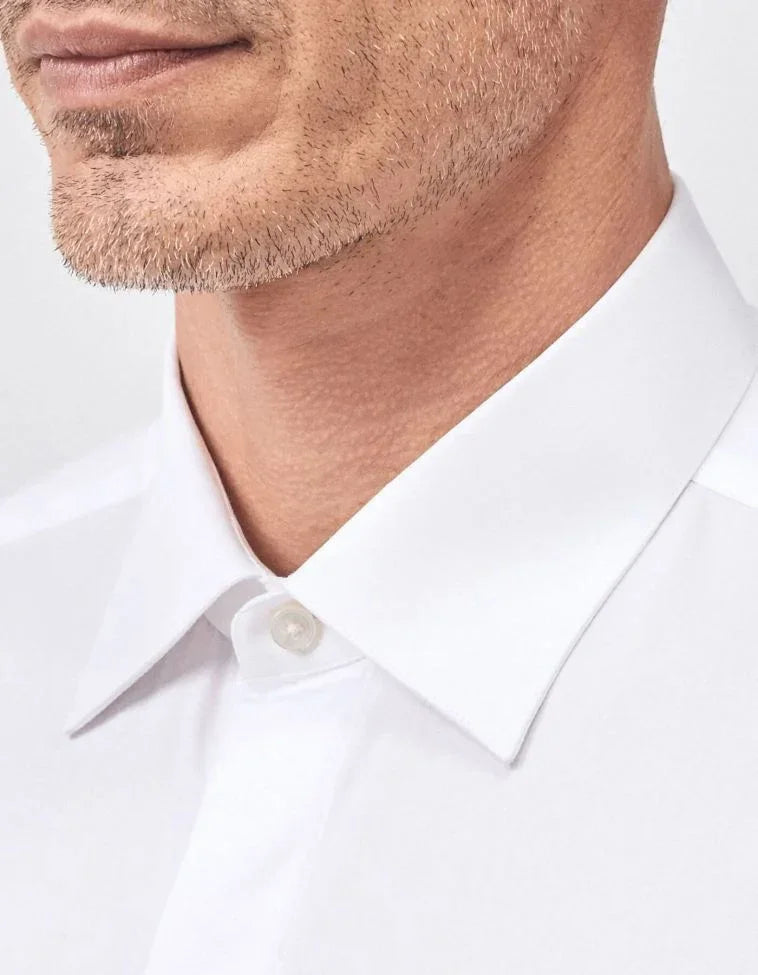 Camicia uomo bianca elegante con collo classico, dettaglio tessuto sartoriale.