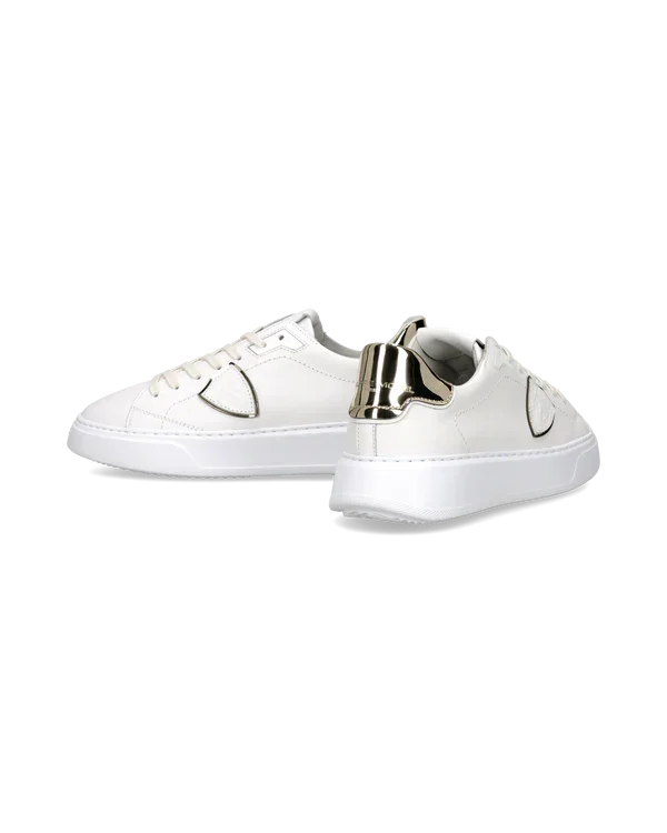 Sneakers bianche da uomo con dettagli metallici dorati e suola piatta