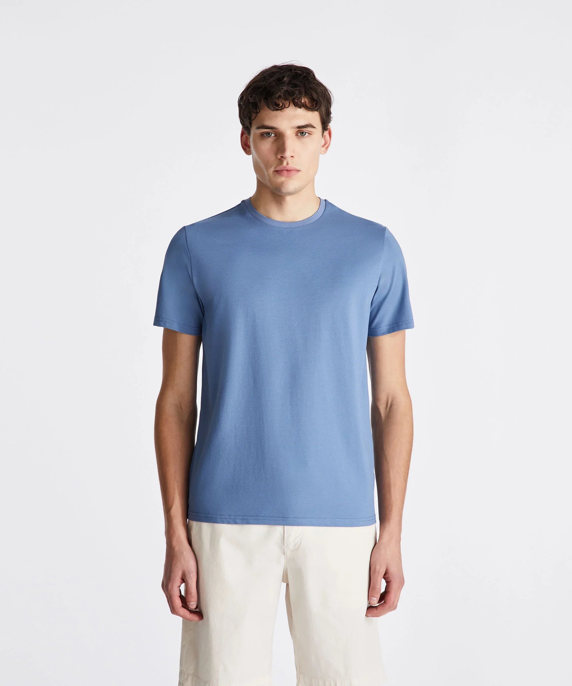 Modello uomo con t-shirt azzurra e bermuda beige, abbigliamento casual estivo