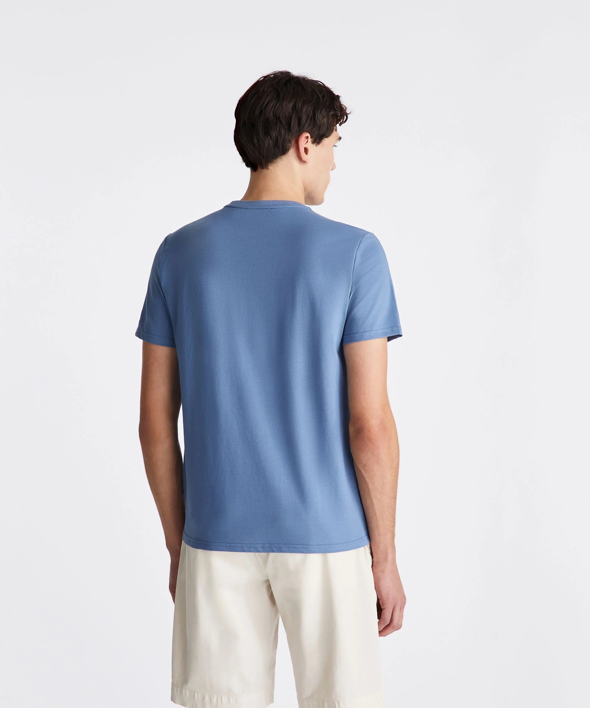 Uomo di spalle con t-shirt azzurra e shorts chiari, abbigliamento estivo casual