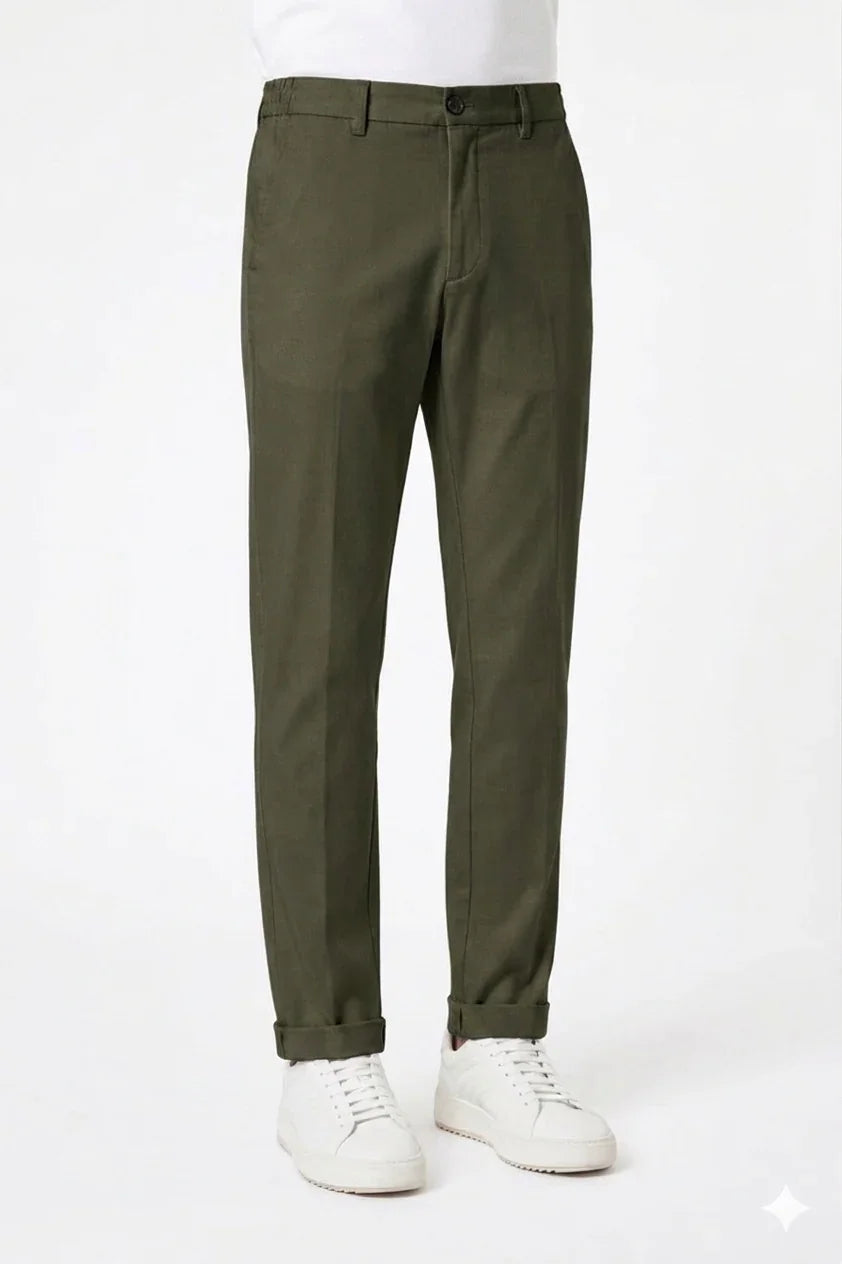 Pantaloni uomo verde oliva eleganti con risvolto, indossati con sneakers bianche