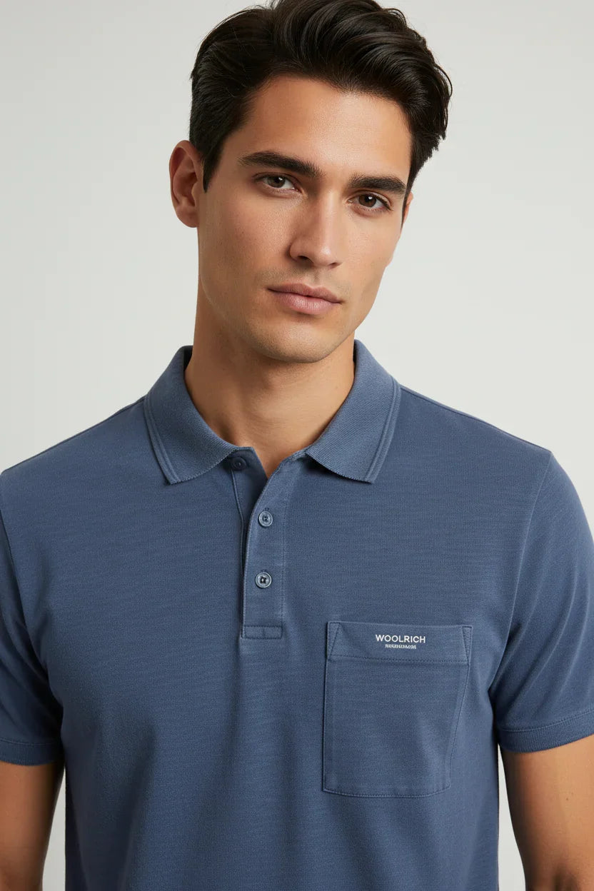 Modello uomo con polo blu Woolrich, stile casual ed elegante, moda uomo primavera estate.