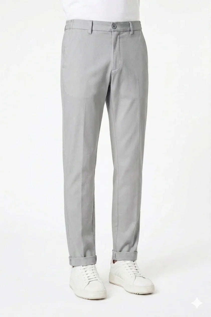 Pantaloni uomo grigi eleganti, vestibilità moderna, abbinati a sneakers bianche