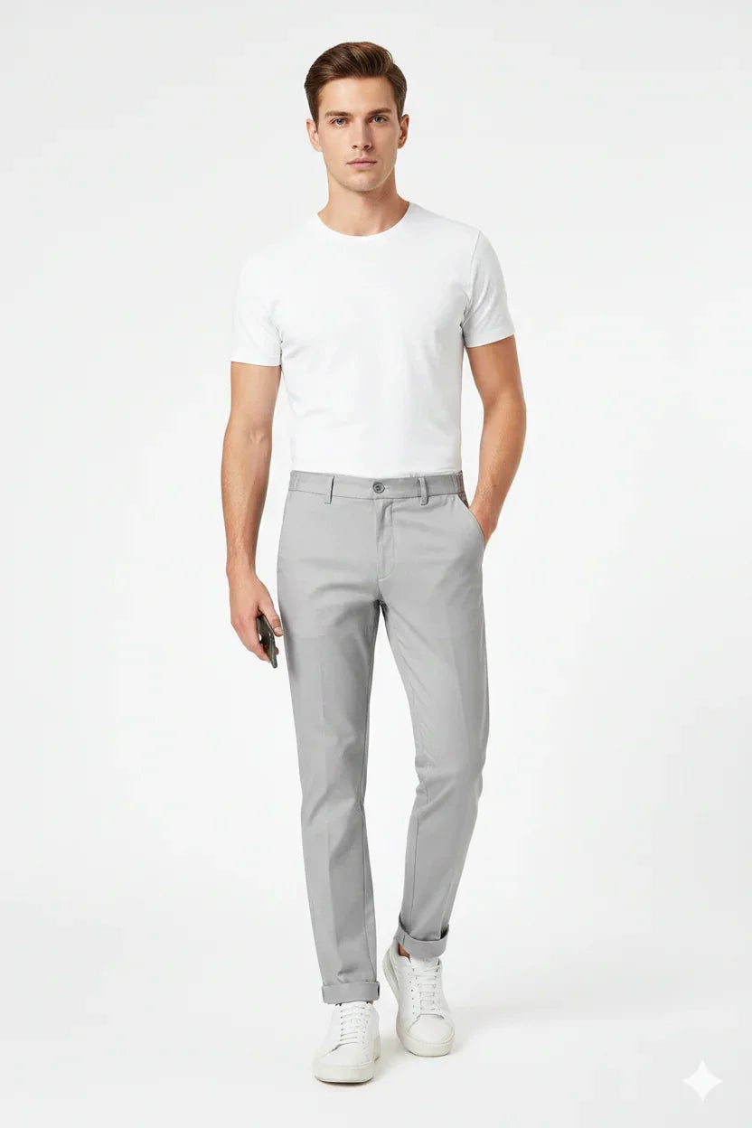 Modello uomo con t-shirt bianca e pantaloni slim fit grigi, stile casual elegante