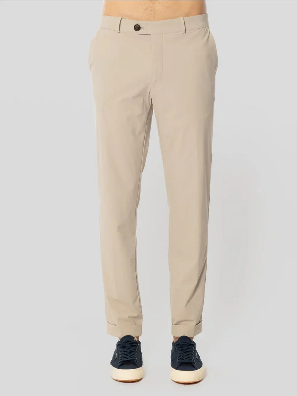 Pantaloni chino beige da uomo con tasche laterali, indossati con sneakers nere