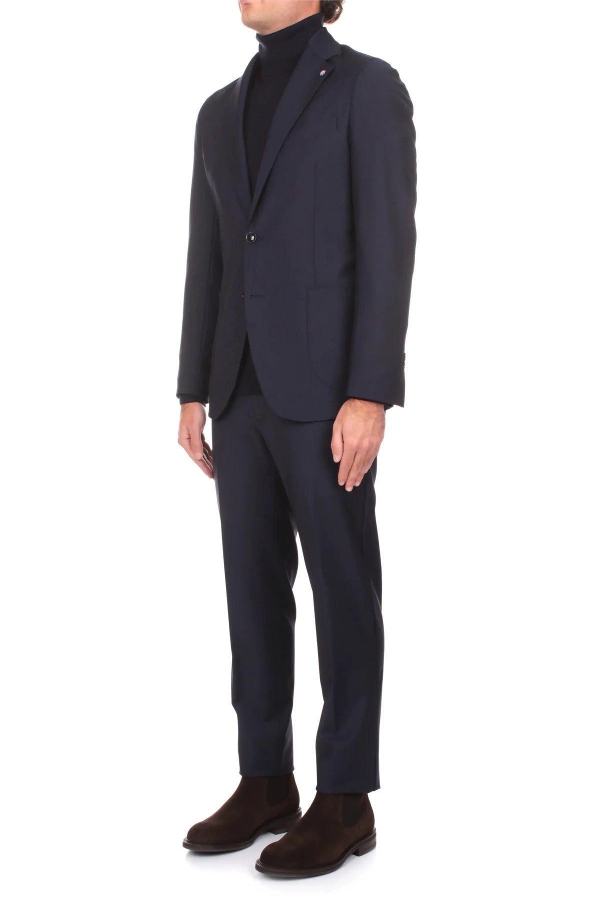 Completo uomo blu elegante, giacca e pantalone, dolcevita nero e stivaletti marroni.