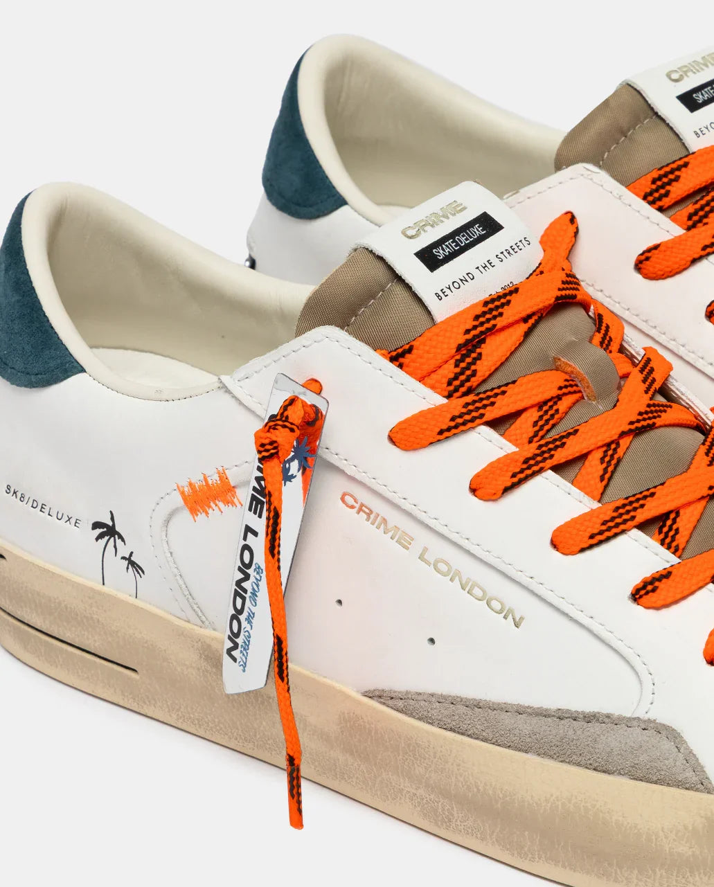 Sneaker uomo Crime London bianca con dettagli arancioni, logo laterale e tallone blu.