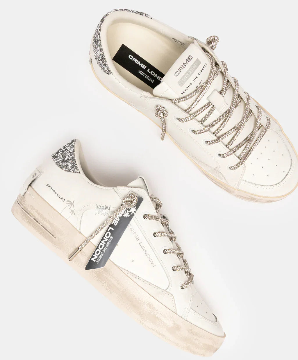 Sneakers bianche donna con dettagli glitter argento, lacci decorativi e suola vintage.