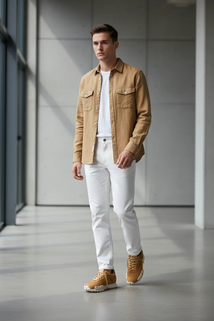 Uomo moderno con camicia beige, jeans bianchi e sneakers color cuoio, moda uomo casual elegante