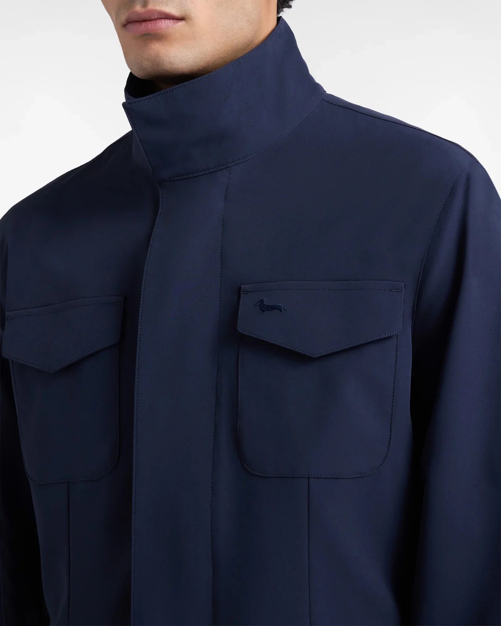 Giacca uomo blu scuro con tasche frontali e colletto alto, stile elegante