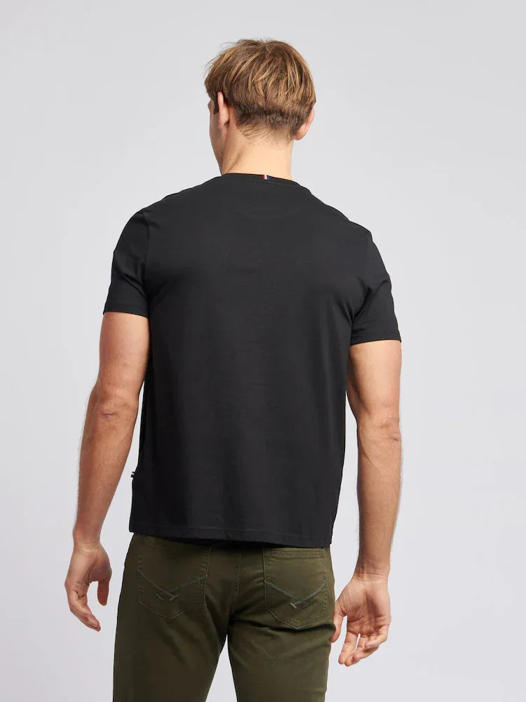 Uomo di spalle indossa t-shirt nera e pantaloni verde militare su sfondo neutro