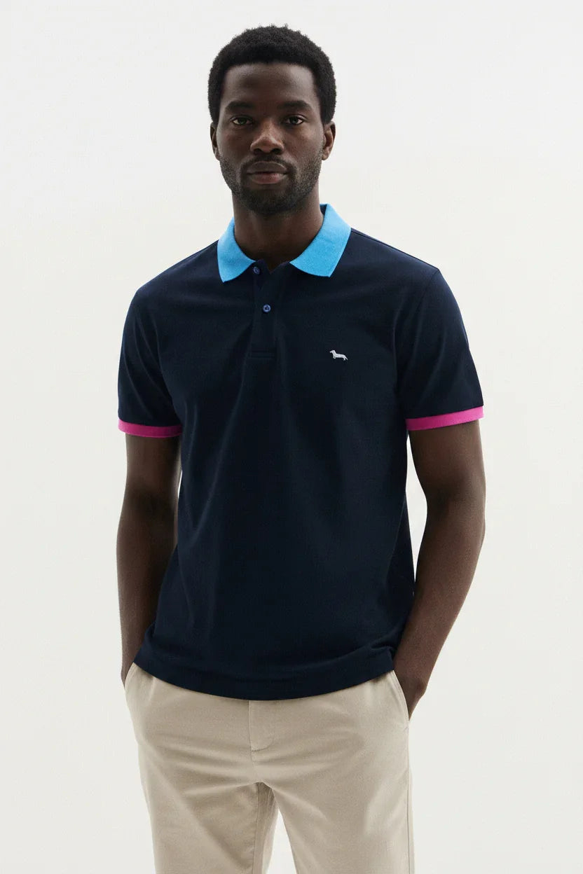 Modello indossa polo blu navy con colletto azzurro e bordi manica rosa, abbigliamento uomo moderno