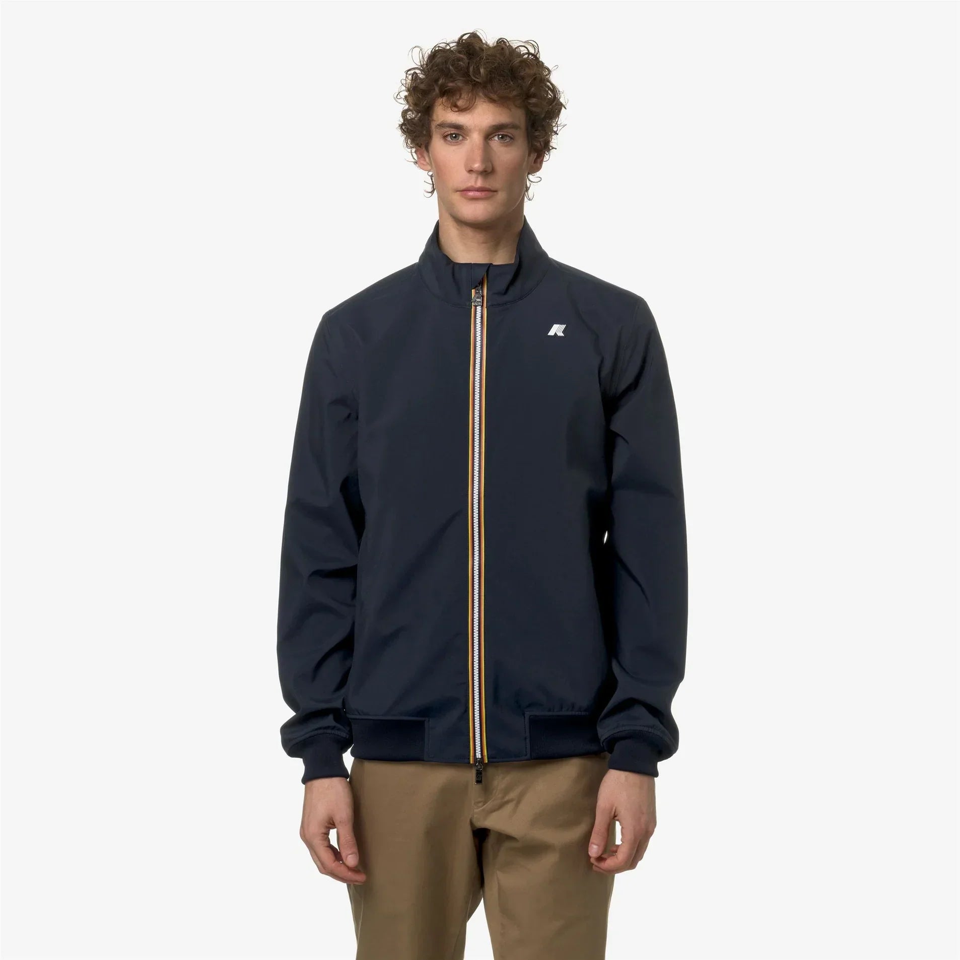 Giacca uomo blu scuro con zip a contrasto e pantaloni beige, moda casual elegante