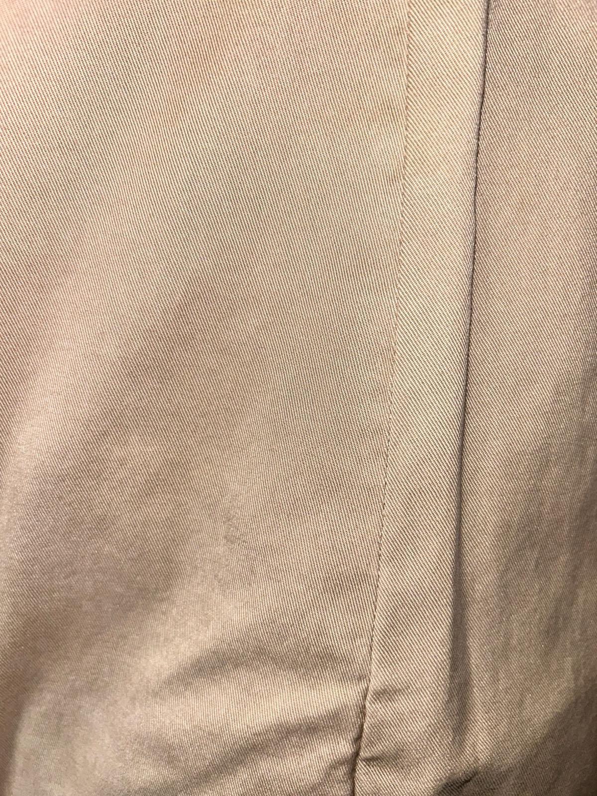 Dettaglio tessuto beige, primo piano di stoffa sartoriale con cucitura visibile
