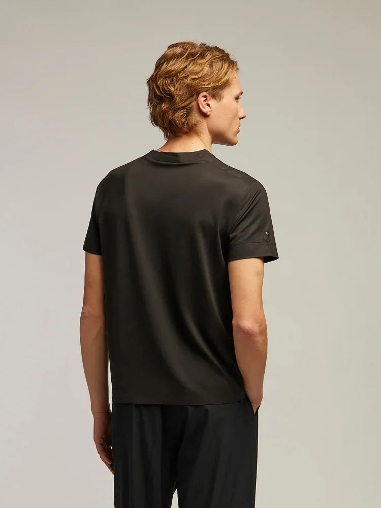 Uomo di spalle indossa t-shirt nera basic, abbigliamento casual uomo, sfondo neutro.