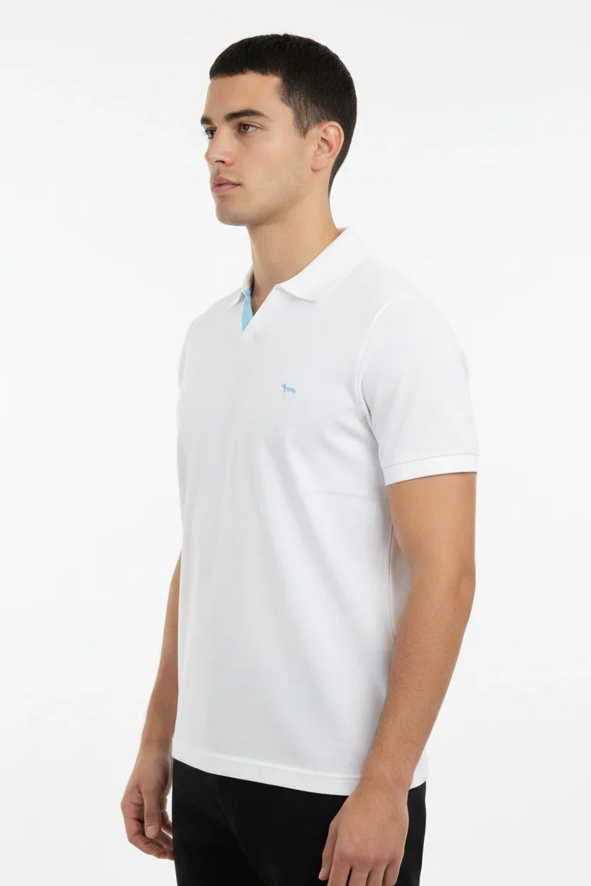 Modello uomo indossa polo bianca a maniche corte con logo azzurro, stile casual elegante