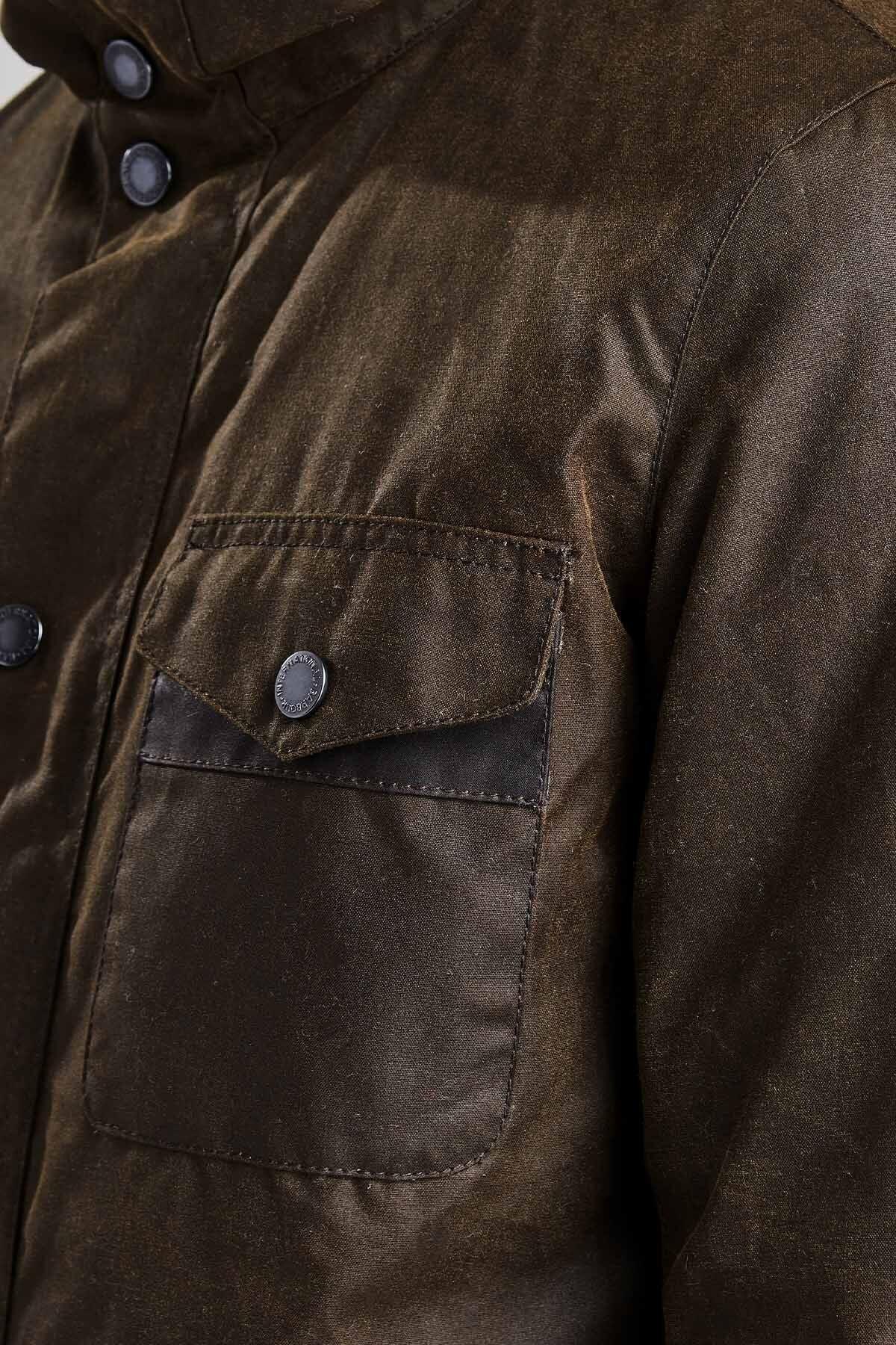 Dettaglio giacca cerata verde da uomo con tasca frontale e bottoni a pressione