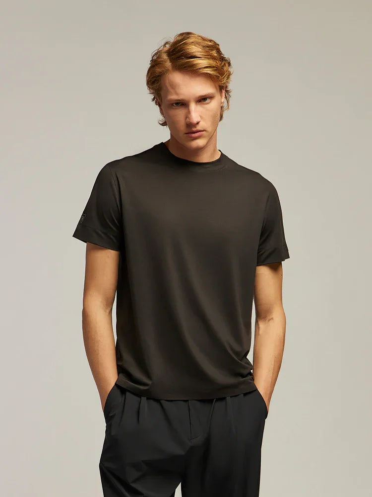 Modello indossa t-shirt nera da uomo a maniche corte e pantaloni scuri, stile casual elegante.