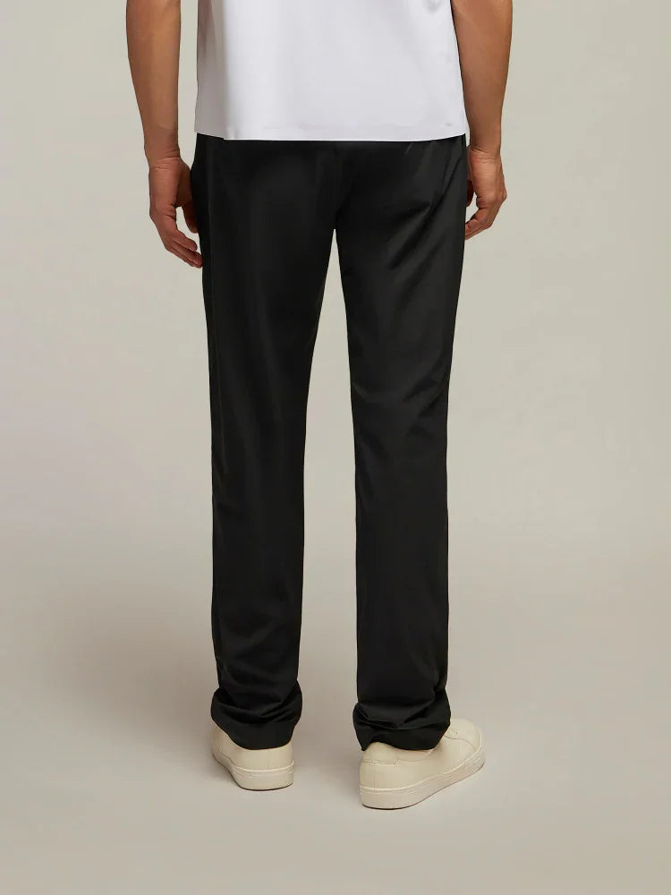 Pantaloni uomo neri eleganti, vestibilità dritta, indossati con scarpe sneakers bianche