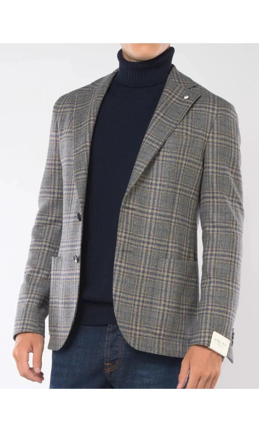 Giacca uomo a quadri beige e blu, tessuto lana, abbinata a dolcevita blu e jeans.