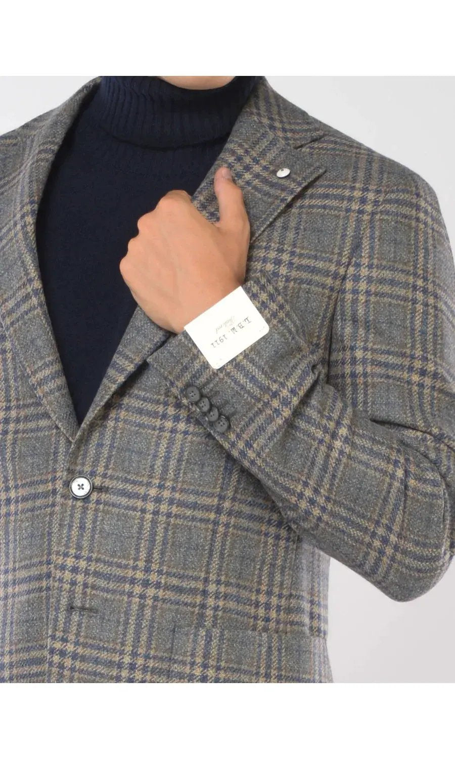 Giacca uomo in lana a quadri beige e blu, con dettagli sartoriali, indossata su dolcevita blu