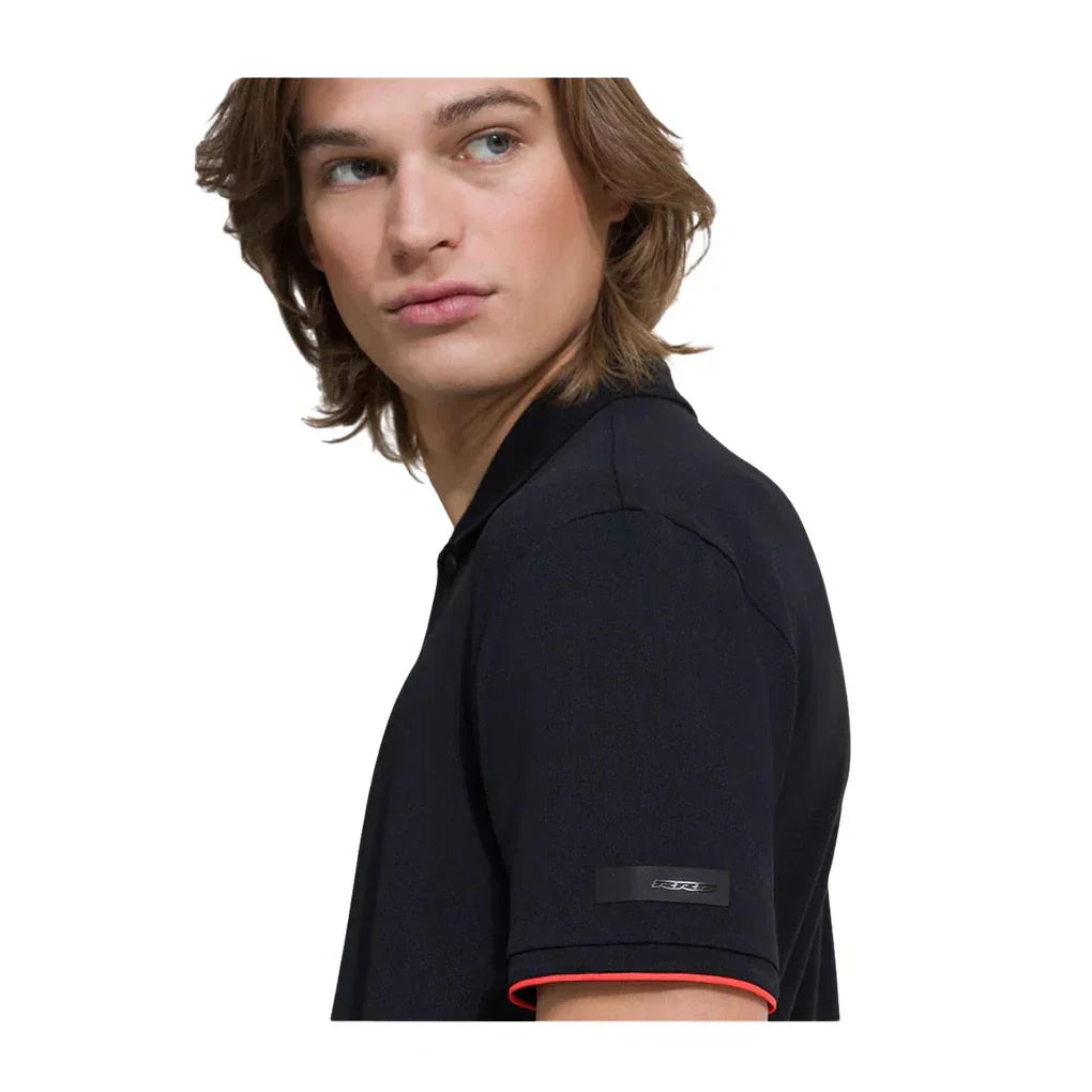 Uomo con polo nera da uomo a maniche corte, dettaglio logo sulla manica e bordo rosso.