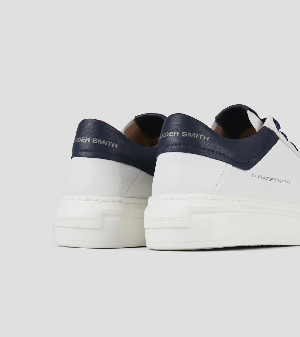 Scarpe da uomo in pelle bianca con dettagli blu e suola spessa, stile casual elegante