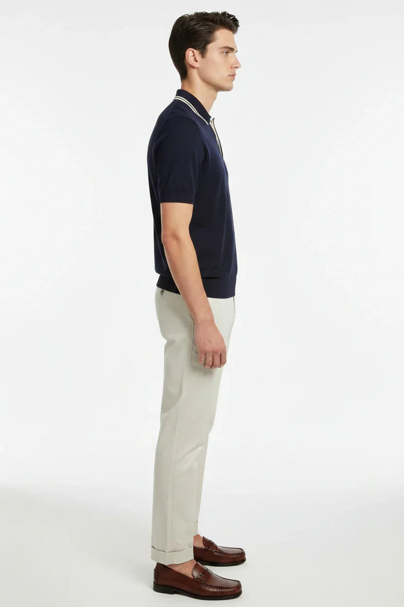 Modello uomo in polo blu navy, pantaloni beige eleganti e mocassini marroni, moda uomo